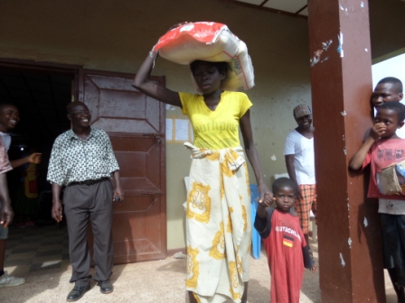 Anna Tarpeh and son receive rice after losing husband to ebola