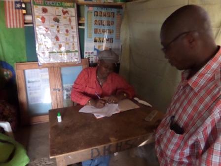 Dominic Hena School's Principal Tellewuo C. Jallah signs
